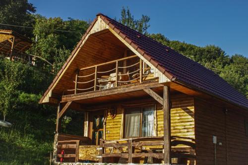 a log cabin with a porch and a balcony at Chalets du BF in Sighişoara