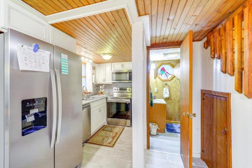 a kitchen with a stainless steel refrigerator and wooden ceilings at 6 Mi to Grandfather Mtn Peaceful Getaway with Grill in Newland