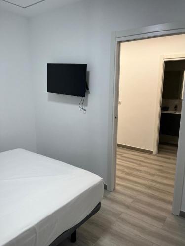 a bedroom with a bed and a flat screen tv on the wall at Villa Amir in Fuengirola