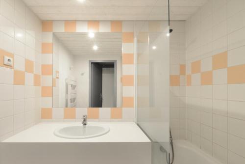 une salle de bain avec un lavabo et un miroir dans l'établissement Résidence Zenith - Studio pour 4 Personnes 114, à La Plagne Tarentaise