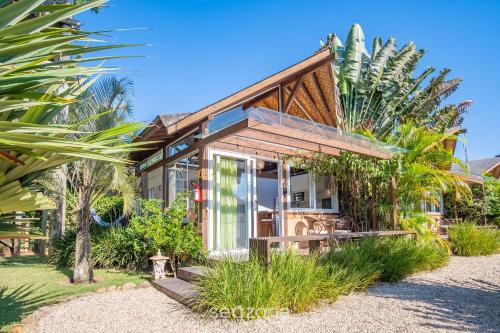 a small house on the beach with palm trees at VGZ - Cabanas charmosas entre Barra de Ibiraquera e Rosa in Imbituba