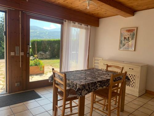 une salle à manger avec une table et des chaises et une fenêtre dans l'établissement Grand Studio cosy, à Sallanches