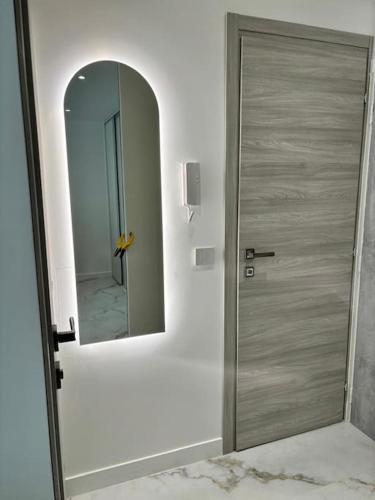 La salle de bains est pourvue d'une porte et d'un miroir. dans l'établissement Superbe studio, à Vallauris