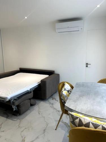 une chambre avec un lit, une table et des chaises dans l'établissement Superbe studio, à Vallauris
