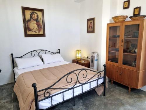 a bedroom with a bed and a wooden cabinet at Villa Christothea in Paphos