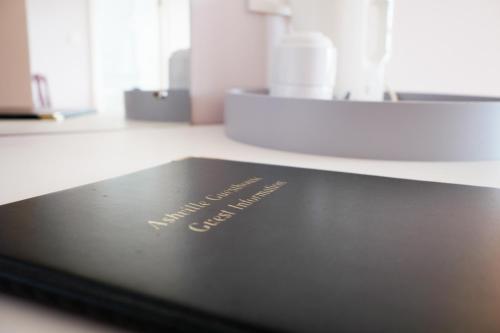 a black book on a counter with the words acupunctureimmune at Ashville Guesthouse in Westport