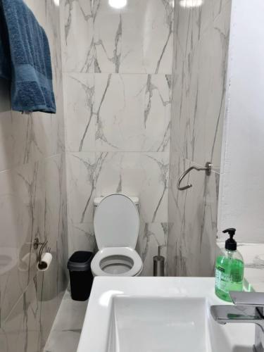 a white bathroom with a toilet and a sink at Villa Christothea in Paphos