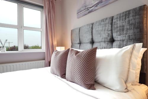 a bedroom with a bed with a large headboard and pillows at Ashville Guesthouse in Westport