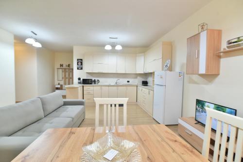 Una cocina y una sala de estar con un sofá y una mesa. en Geny's House, en Shkodër