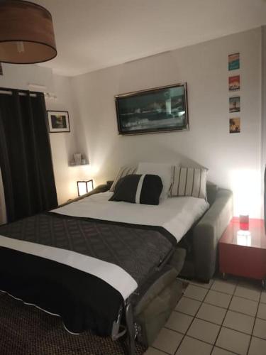 une chambre avec un grand lit et un canapé dans l'établissement Studio jardin 300 m plage, à Carnac