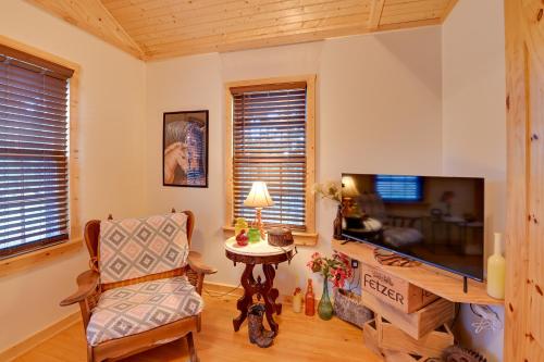 a living room with a television and a chair at Cozy Beattyville Cabin with Fire Pit and Hot Tub in Beattyville