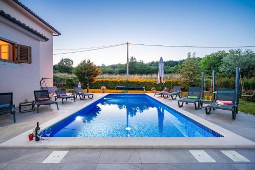 KršanにあるVilla Milenaの椅子付きの庭のスイミングプール
