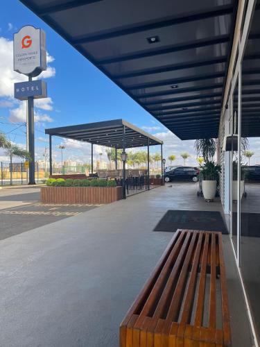 a bus stop with a bench in a parking lot at Golden Tower Aeroporto - Lizz - by Fênix Hotéis in Uberlândia