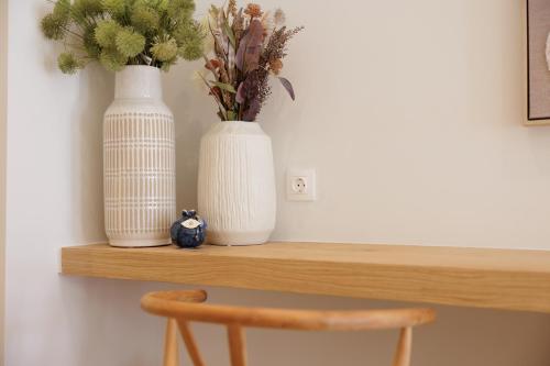 two white vases sitting on a wooden shelf at Celestial Suites-TOP LOCATION in Corfu Town