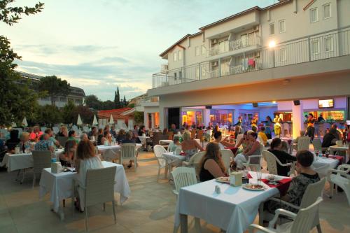 a group of people sitting at tables in a restaurant at Catty Cats Garden Hotel in Side