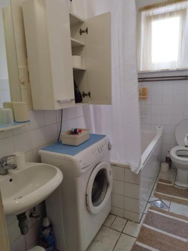 a bathroom with a washing machine and a sink at Tin in Slavonski Brod