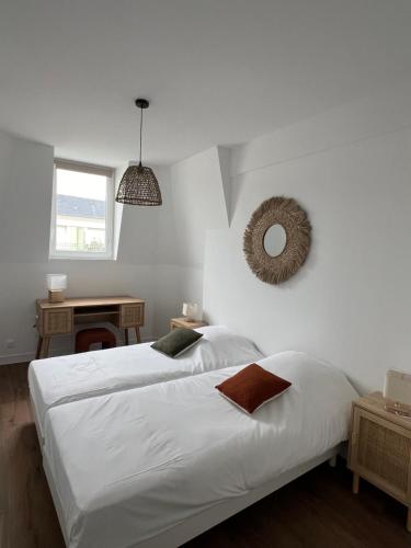 une chambre avec deux lits et un miroir au mur dans l'établissement Villa Saint Louis 5, à Cabourg