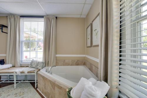 a bathroom with a tub and a window at The Cabernet Cabin Defiance Home on Katy Trail! in Defiance