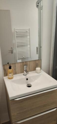 une salle de bain avec un lavabo blanc et un miroir dans l'établissement Lumineux appartement climatisé, à Montpellier