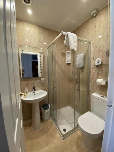 a bathroom with a shower and a toilet and a sink at Fairhaven Holiday Flats in Blackpool