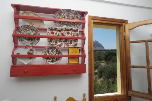 a shelf with plates on a wall next to a window at Athena Villas Olive Grove & Estate in Gouves