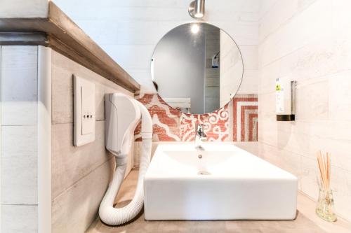 a bathroom with a white sink and a mirror at Logis Hôtel & Restaurant Le Cadet de Gascogne in Saint-Justin