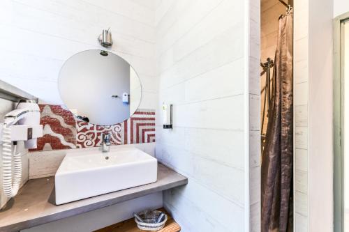 a bathroom with a sink and a mirror at Logis Hôtel & Restaurant Le Cadet de Gascogne in Saint-Justin