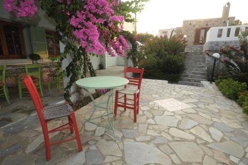 a table and two chairs and a table with pink flowers at Athena Villas Olive Grove & Estate in Gouves