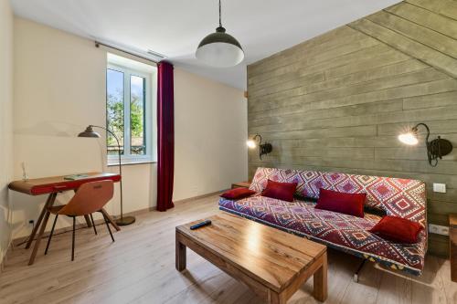 a living room with a couch and a table at Logis Hôtel & Restaurant Le Cadet de Gascogne in Saint-Justin