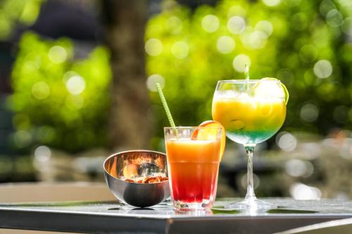 three cocktails on a tray on a table at Logis Hôtel & Restaurant Le Cadet de Gascogne in Saint-Justin