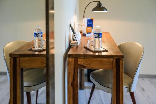 a table with two chairs and two water bottles on it at Logis Hôtel & Restaurant Le Cadet de Gascogne in Saint-Justin