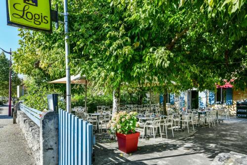 a group of tables and chairs on a sidewalk at Logis Hôtel & Restaurant Le Cadet de Gascogne in Saint-Justin