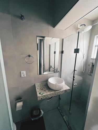 a bathroom with a sink and a mirror at Pousada Serra Branca in São Thomé das Letras