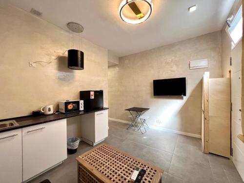 a room with a kitchen with a tv on the wall at Suite N25 in Madrid