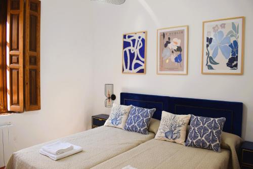 a bedroom with a bed with blue and white pillows at Casa Rístori San Isidro in Manzanares
