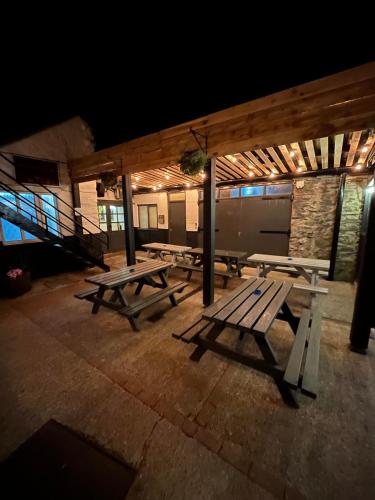 a group of picnic tables on a patio at night at Plas Coch Hotel Ltd in Bala