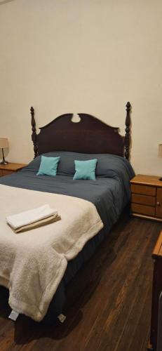 モンテビデオにあるApartamento en Edificio Palacio Colónの青い枕が付いた大きなベッドのある寝室