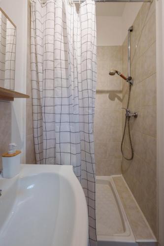 une salle de bain avec douche et baignoire blanche dans l'établissement Appartement cosy proche de la gare, à Saint-Quentin
