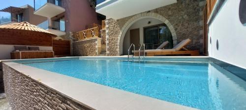 a swimming pool in a villa with a house at Filoxenia Sea View in Parga