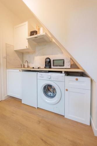 une cuisine avec lave-linge et sèche-linge dans une maison dans l'établissement Appartement cosy proche de la gare, à Saint-Quentin