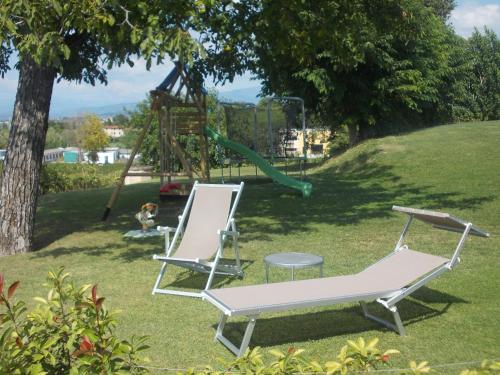two chairs and a table and a playground at Agriturismo Ca' Vecia in Castelnuovo del Garda
