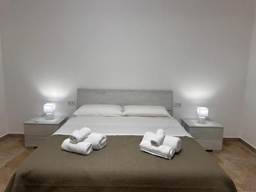 una camera da letto con un letto grande con asciugamani sopra di Casa felicità Sciacca a Sciacca