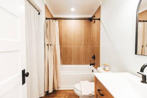 a bathroom with a tub and a toilet and a sink at NEW! 1937 Coastal Cottage by Beach, Boardwalk, & Lake! in Carolina Beach