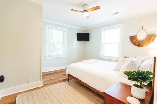 a bedroom with a white bed and a ceiling fan at NEW! 1937 Coastal Cottage by Beach, Boardwalk, & Lake! in Carolina Beach