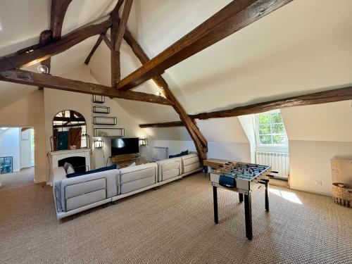 ein Wohnzimmer mit Sofa und Tisch in der Unterkunft Maison de campagne proche de Paris in Vienne-en-Arthies