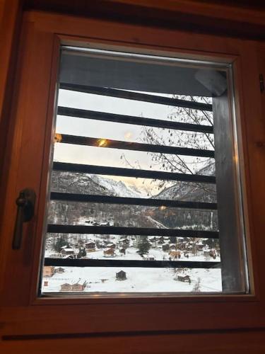 a window with a view of a snow covered field at Magnifique racard rénové isolé 10 minutes de marche in Haudères