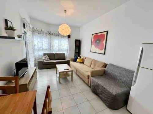a living room with a couch and a table at Niove Budget One-Bedroom Apartment in Paralimni