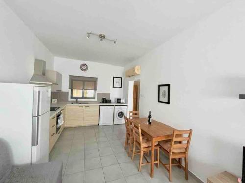 a kitchen with a wooden table and a refrigerator at Niove Budget One-Bedroom Apartment in Paralimni