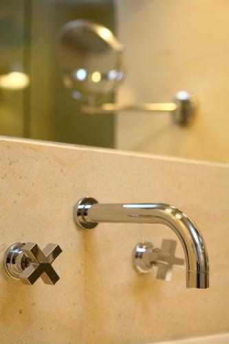 a bathroom sink with a faucet and a mirror at O&B Athens Boutique Hotel in Athens