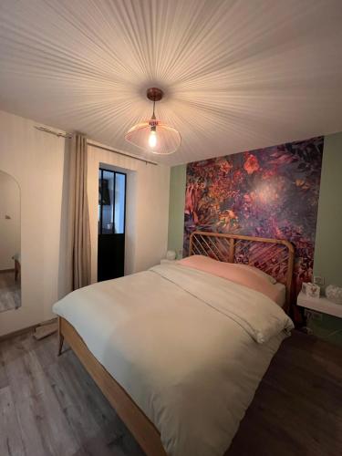 une chambre avec un grand lit avec un tableau au mur dans l'établissement Cocon sur la Route des Vins, à Gertwiller